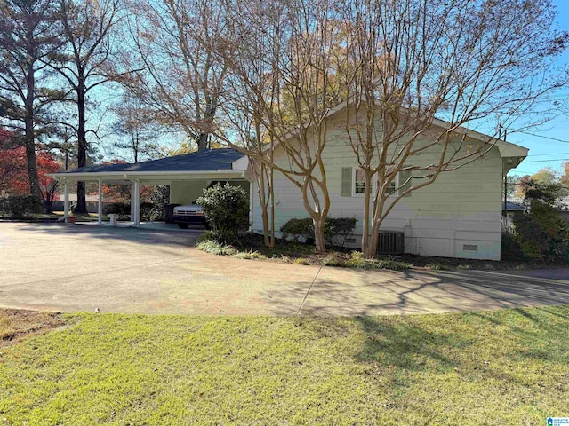 view of side of home featuring central AC, a yard, and a carport