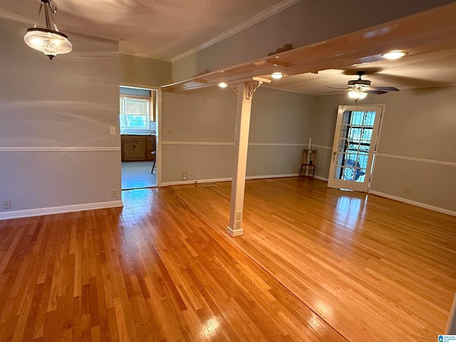 spare room featuring a textured ceiling, light hardwood / wood-style floors, ceiling fan, and crown molding