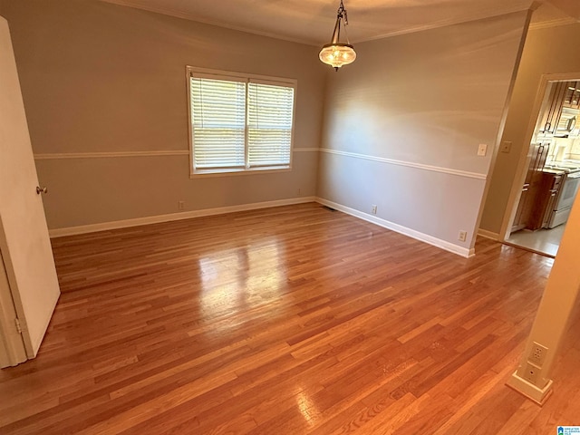 empty room featuring ornamental molding and hardwood / wood-style flooring