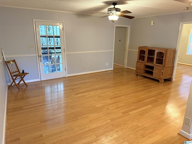 1807 Moncrief Rd, Gardendale, AL 35071 - unfurnished living room featuring ceiling fan, plenty of natural light, light wood finished floors, ornamental molding, and a textured ceiling