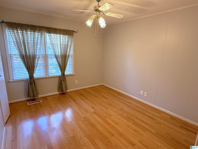 spare room with ceiling fan, ornamental molding, a textured ceiling, and light hardwood / wood-style flooring