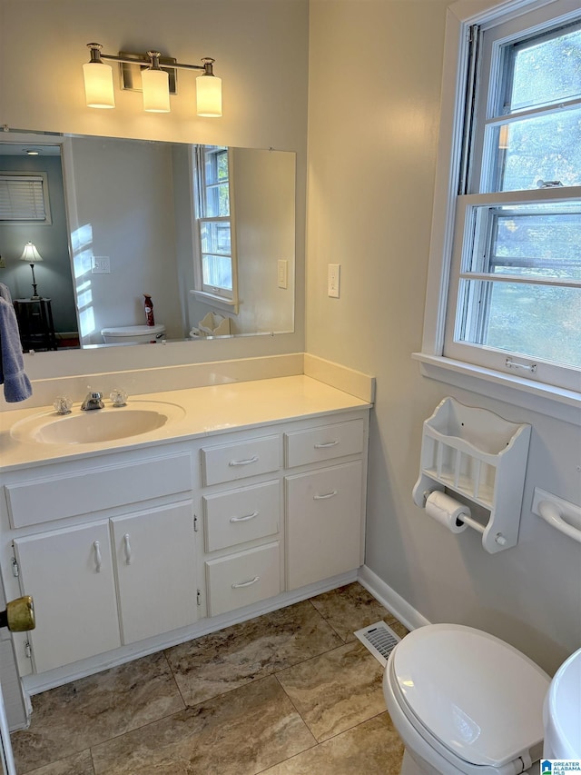 1807 Moncrief Rd, Gardendale, AL 35071 - bathroom featuring toilet, healthy amount of natural light, vanity, and baseboards
