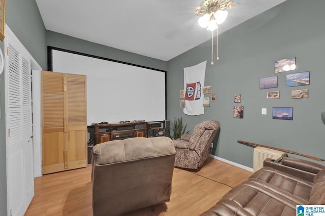 cinema room with ceiling fan and light hardwood / wood-style floors