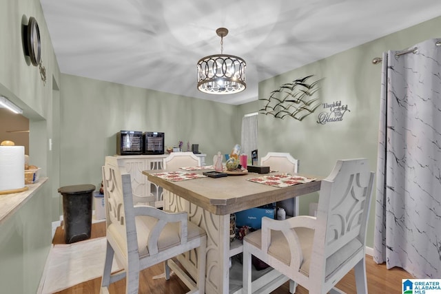 dining space featuring light hardwood / wood-style flooring and an inviting chandelier