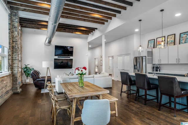 dining area with beam ceiling, sink, and dark wood-type flooring