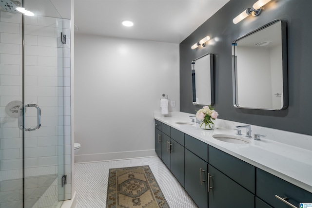 bathroom with tile patterned floors, vanity, an enclosed shower, and toilet