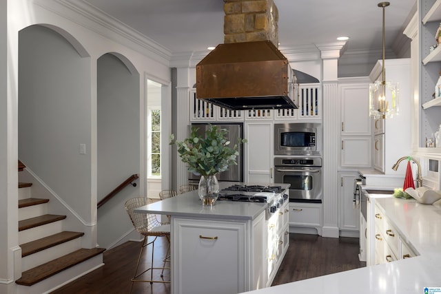 kitchen featuring white cabinets, decorative light fixtures, premium range hood, and stainless steel appliances