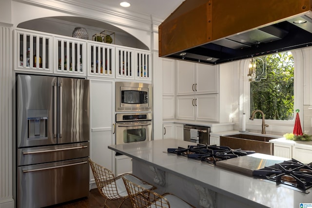 kitchen featuring island exhaust hood, dark hardwood / wood-style flooring, stainless steel appliances, sink, and white cabinets