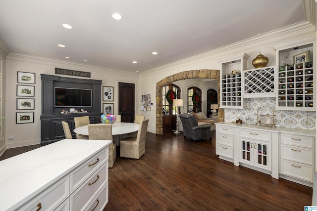 kitchen featuring tasteful backsplash, dark wood-type flooring, and ornamental molding