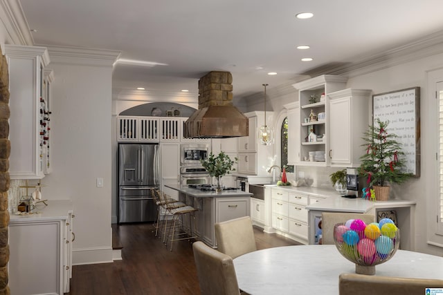 kitchen featuring hanging light fixtures, a breakfast bar area, dark hardwood / wood-style floors, range hood, and stainless steel appliances