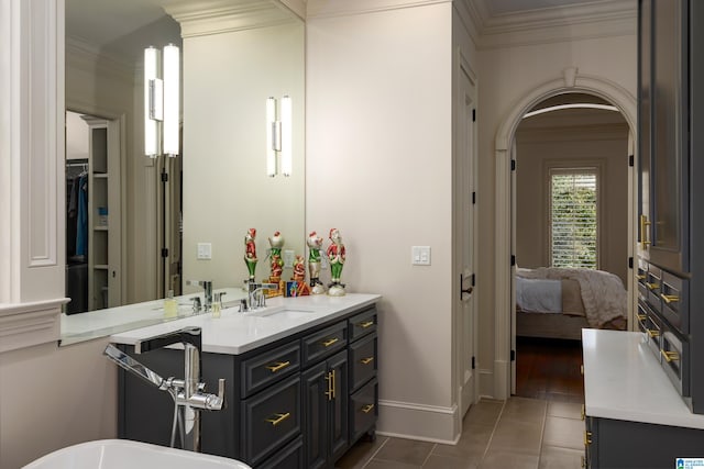 bathroom with crown molding, tile patterned flooring, and vanity