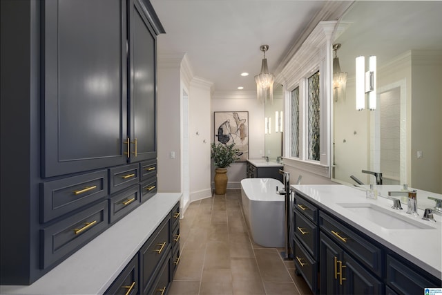 bathroom with a bathing tub, vanity, tile patterned floors, and crown molding