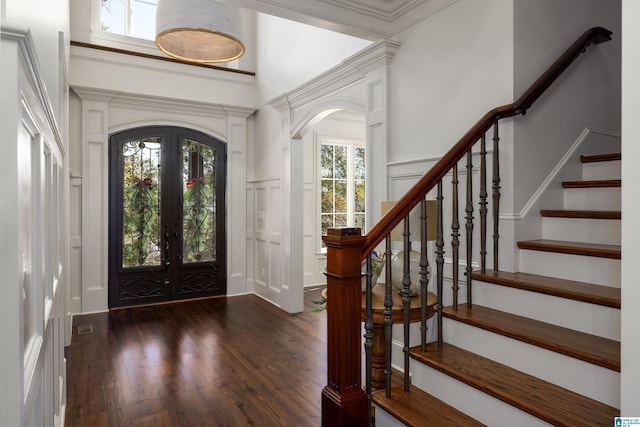 foyer entrance featuring dark hardwood / wood-style flooring, french doors, plenty of natural light, and ornamental molding