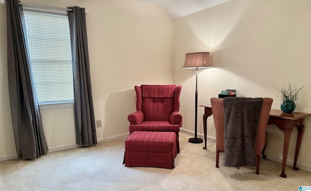 living area featuring plenty of natural light, vaulted ceiling, and light carpet