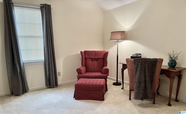 living area featuring lofted ceiling, a healthy amount of sunlight, and light colored carpet