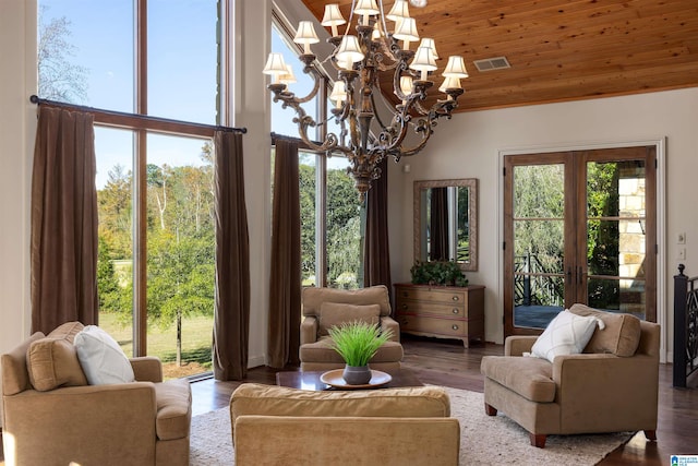 sunroom featuring a notable chandelier, plenty of natural light, wooden ceiling, and french doors