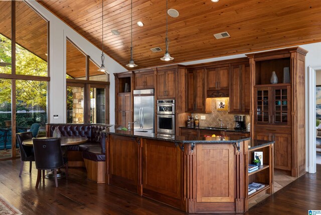 kitchen with stainless steel appliances, vaulted ceiling, dark wood-type flooring, pendant lighting, and wooden ceiling