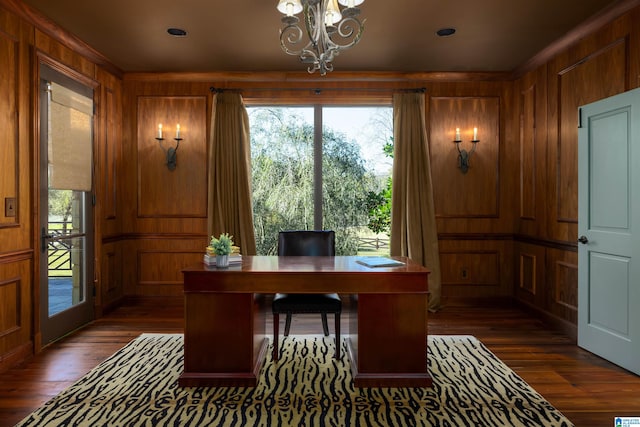 home office with wood walls, dark hardwood / wood-style flooring, and an inviting chandelier