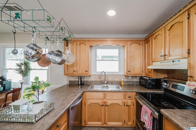 kitchen featuring a textured ceiling, stainless steel appliances, backsplash, and sink