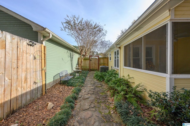 view of home's exterior featuring a sunroom and central AC