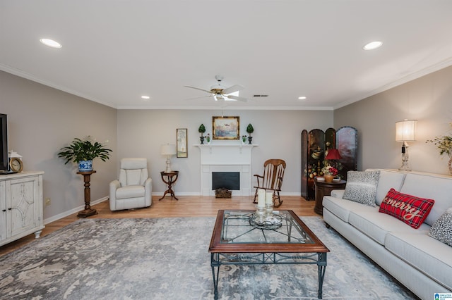 living room with wood-type flooring, ceiling fan, and ornamental molding