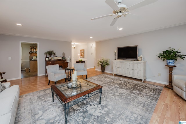 living room featuring ceiling fan, wood-type flooring, and ornamental molding