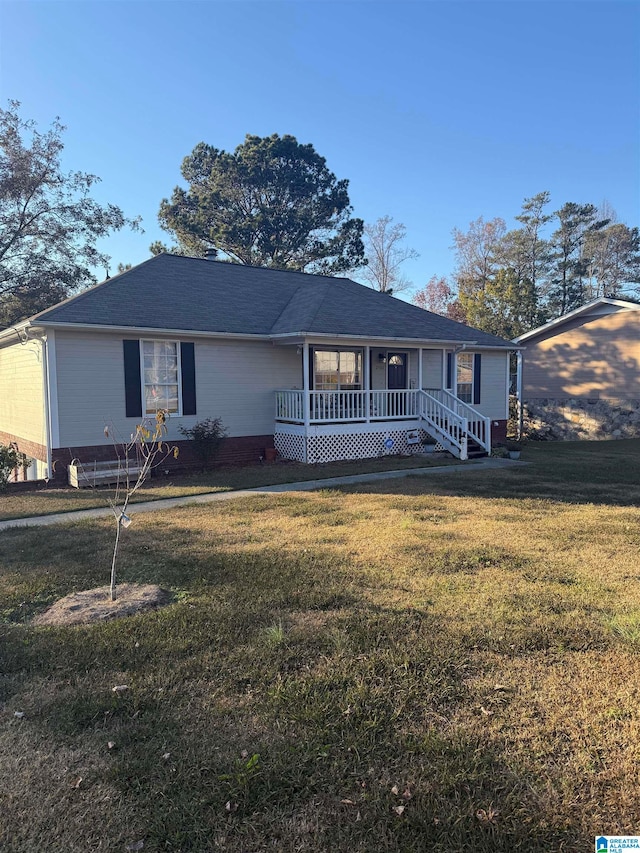 ranch-style home featuring covered porch and a front lawn