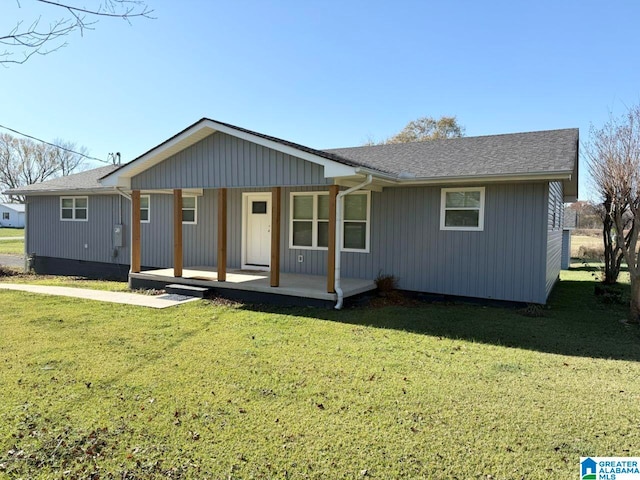 ranch-style house featuring covered porch and a front lawn