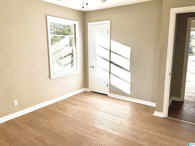 empty room with ceiling fan and light wood-type flooring