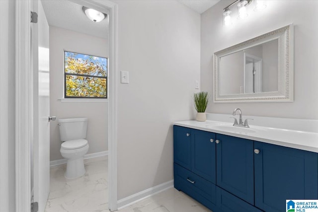 bathroom featuring vanity, toilet, and a textured ceiling