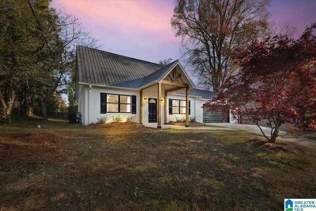 modern farmhouse style home featuring a lawn and a garage