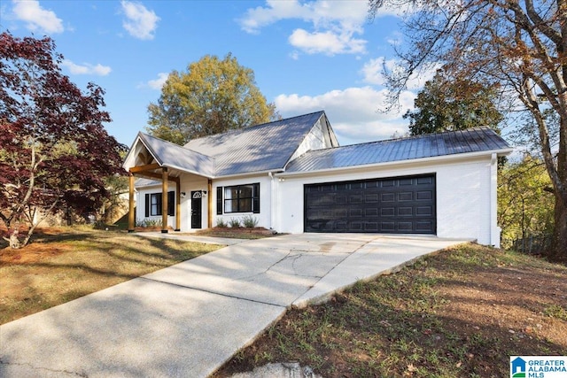 modern inspired farmhouse with a front yard and a garage