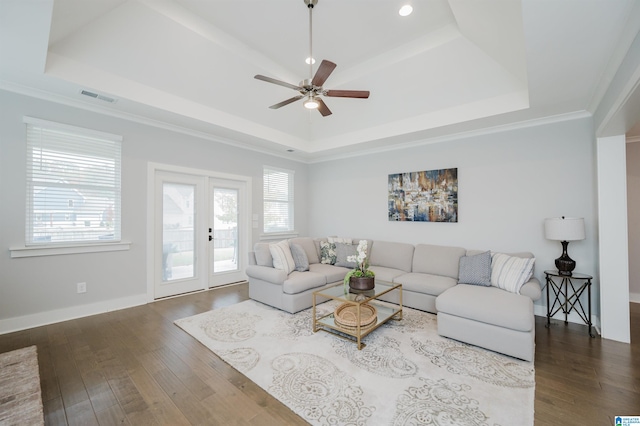 living room with hardwood / wood-style flooring, ceiling fan, a tray ceiling, and french doors