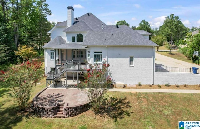 rear view of house featuring a yard and a deck