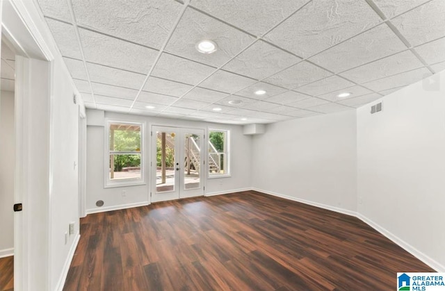 unfurnished room with a paneled ceiling, french doors, and dark hardwood / wood-style floors