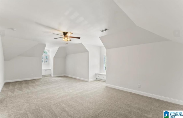 bonus room with plenty of natural light, light carpet, and vaulted ceiling