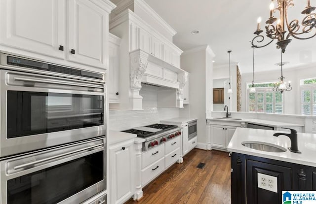 kitchen featuring dark wood-type flooring, crown molding, sink, appliances with stainless steel finishes, and white cabinetry