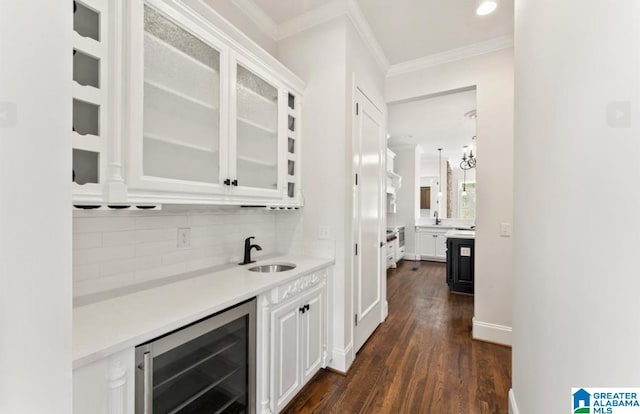 bar with wine cooler, white cabinets, and dark wood-type flooring