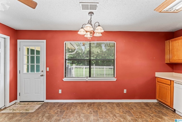 unfurnished dining area with a notable chandelier and a textured ceiling