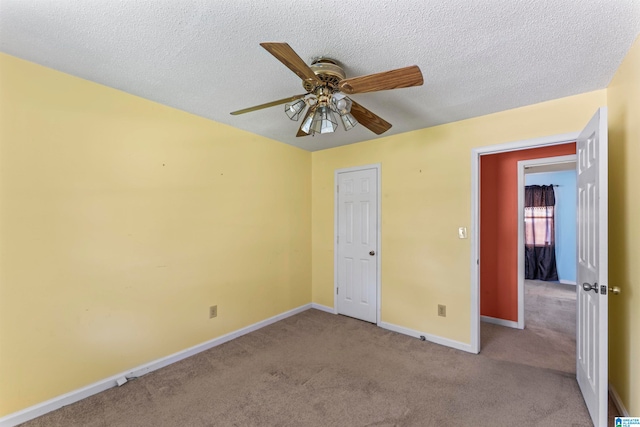 unfurnished bedroom with light carpet, a textured ceiling, and ceiling fan