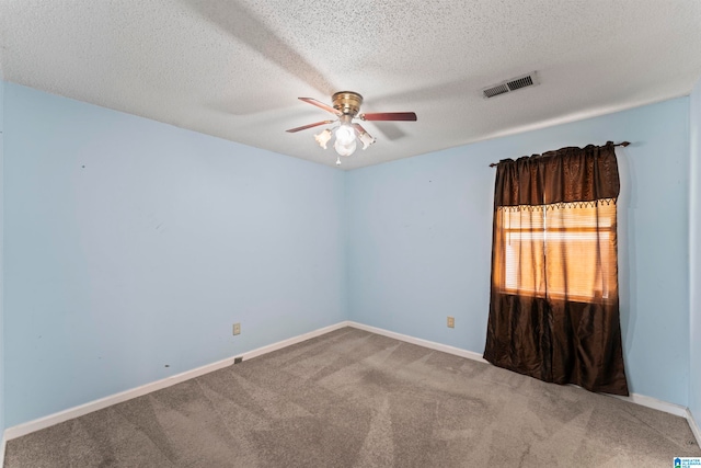 spare room featuring ceiling fan, carpet floors, and a textured ceiling