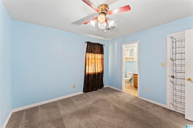 carpeted spare room with ceiling fan and a textured ceiling