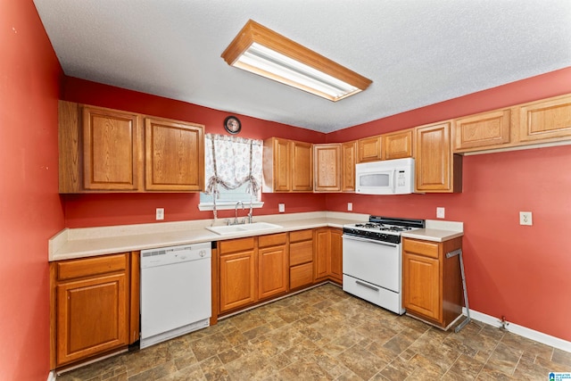 kitchen with a textured ceiling, white appliances, and sink