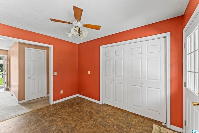 unfurnished bedroom with a textured ceiling, a closet, multiple windows, and ceiling fan