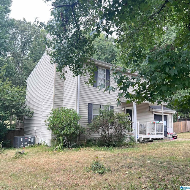 view of front of house featuring a front yard, central air condition unit, and a wooden deck