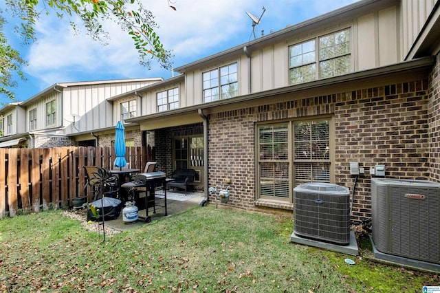 rear view of house with a patio area, a yard, and central AC unit