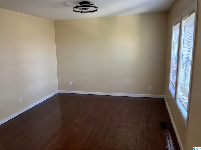 unfurnished room with dark wood-type flooring