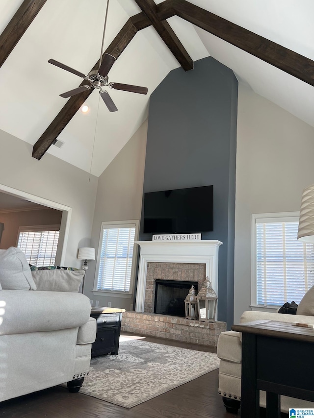 living room with dark hardwood / wood-style flooring, beamed ceiling, and a healthy amount of sunlight