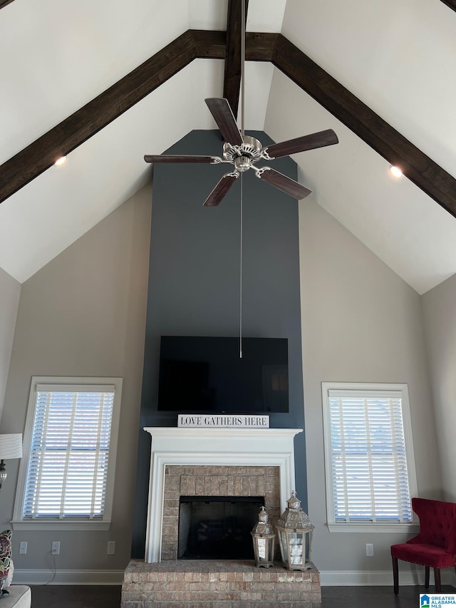 living room featuring beam ceiling, a fireplace, plenty of natural light, and high vaulted ceiling