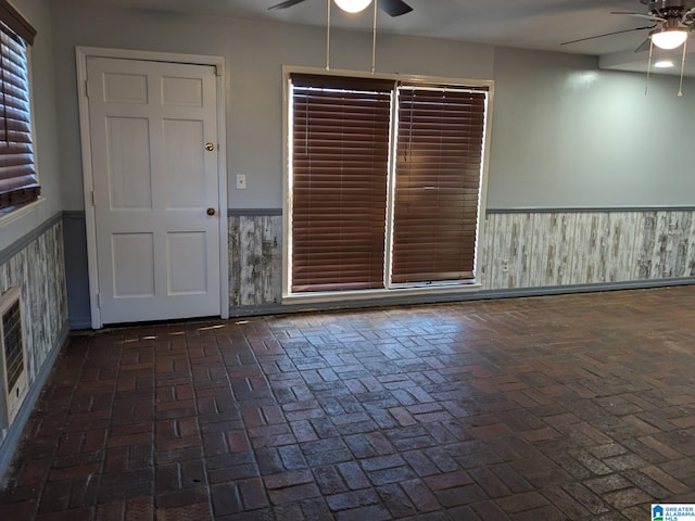 spare room featuring ceiling fan and a fireplace